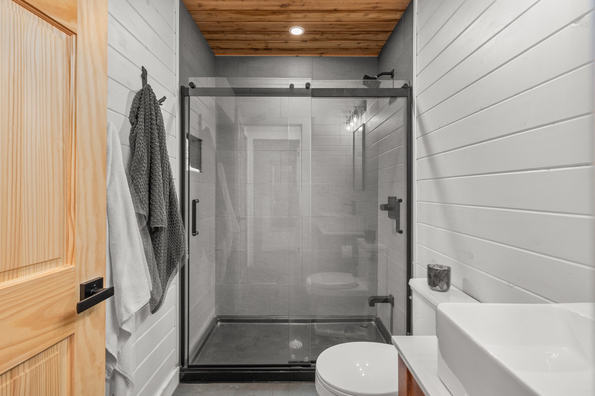 A glass walk-in shower with white wall tiles
