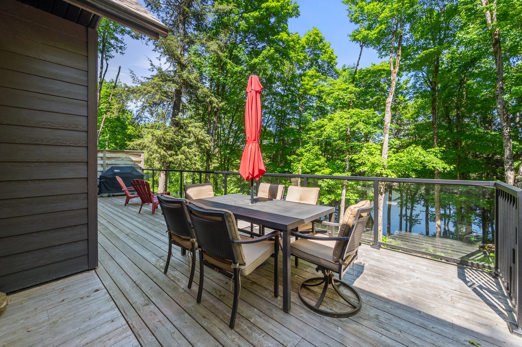 A dining table with a closed red umbrella