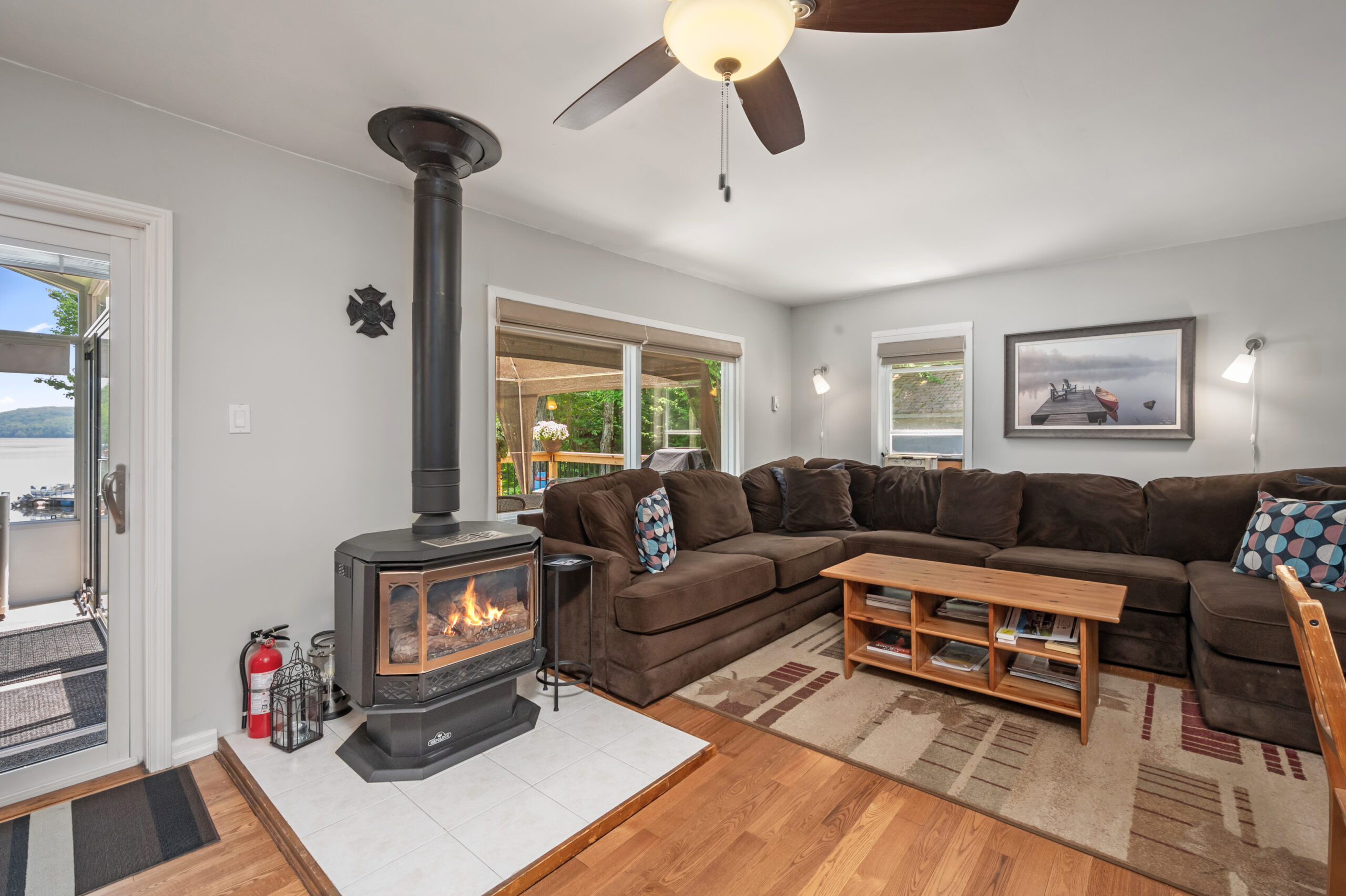 A wood stove next to an L-shaped brown velvet couch