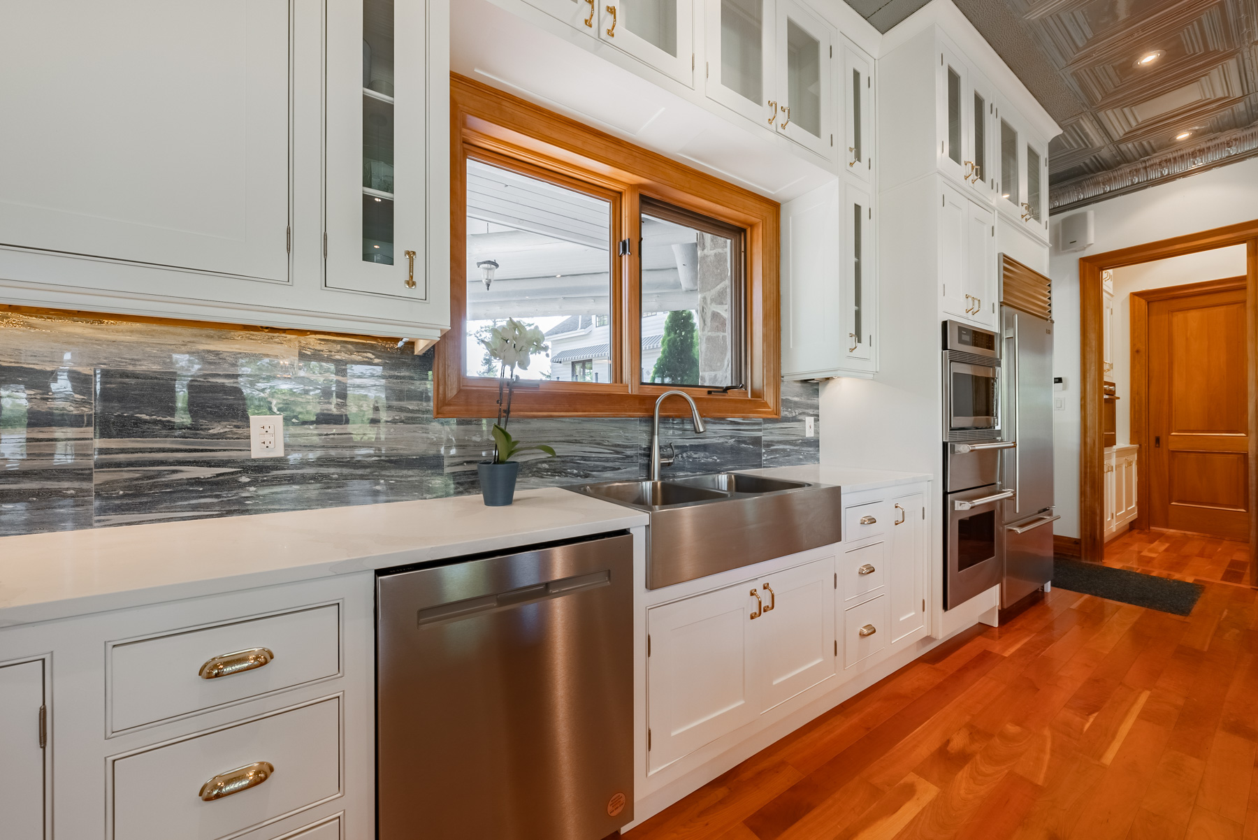 A wall of white cabinets and drawers with a stainless steel dishwasher
