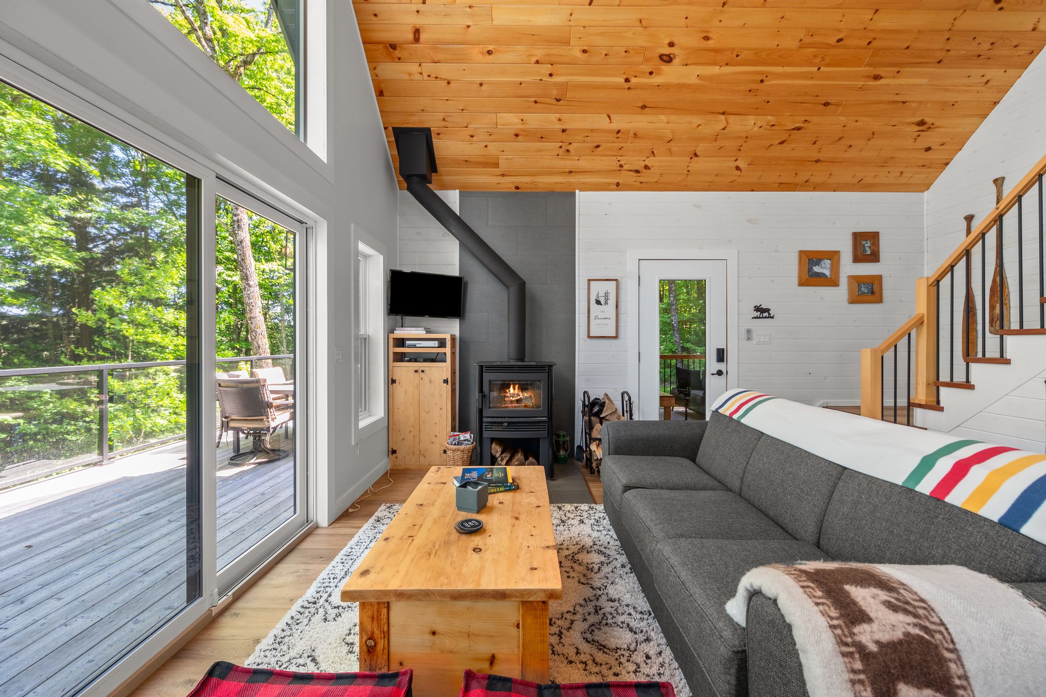 A grey couch faces a wall of windows
