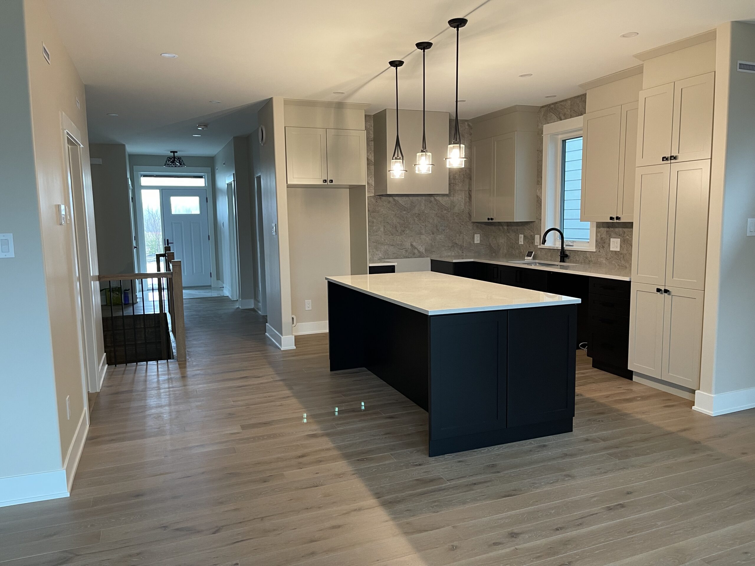A spacious room with a large kitchen island with white countertops