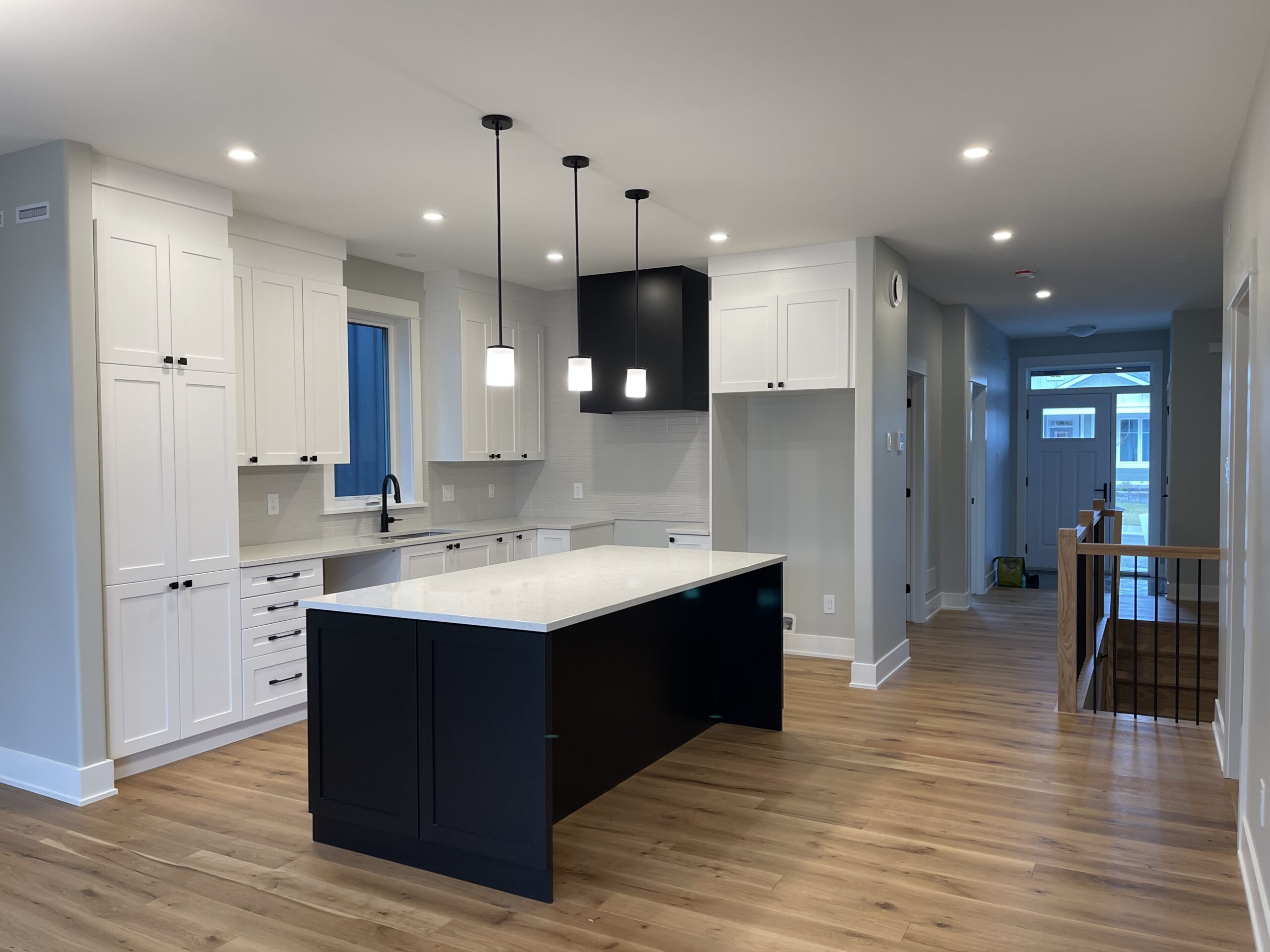A large kitchen island with white countertops in a spacious room