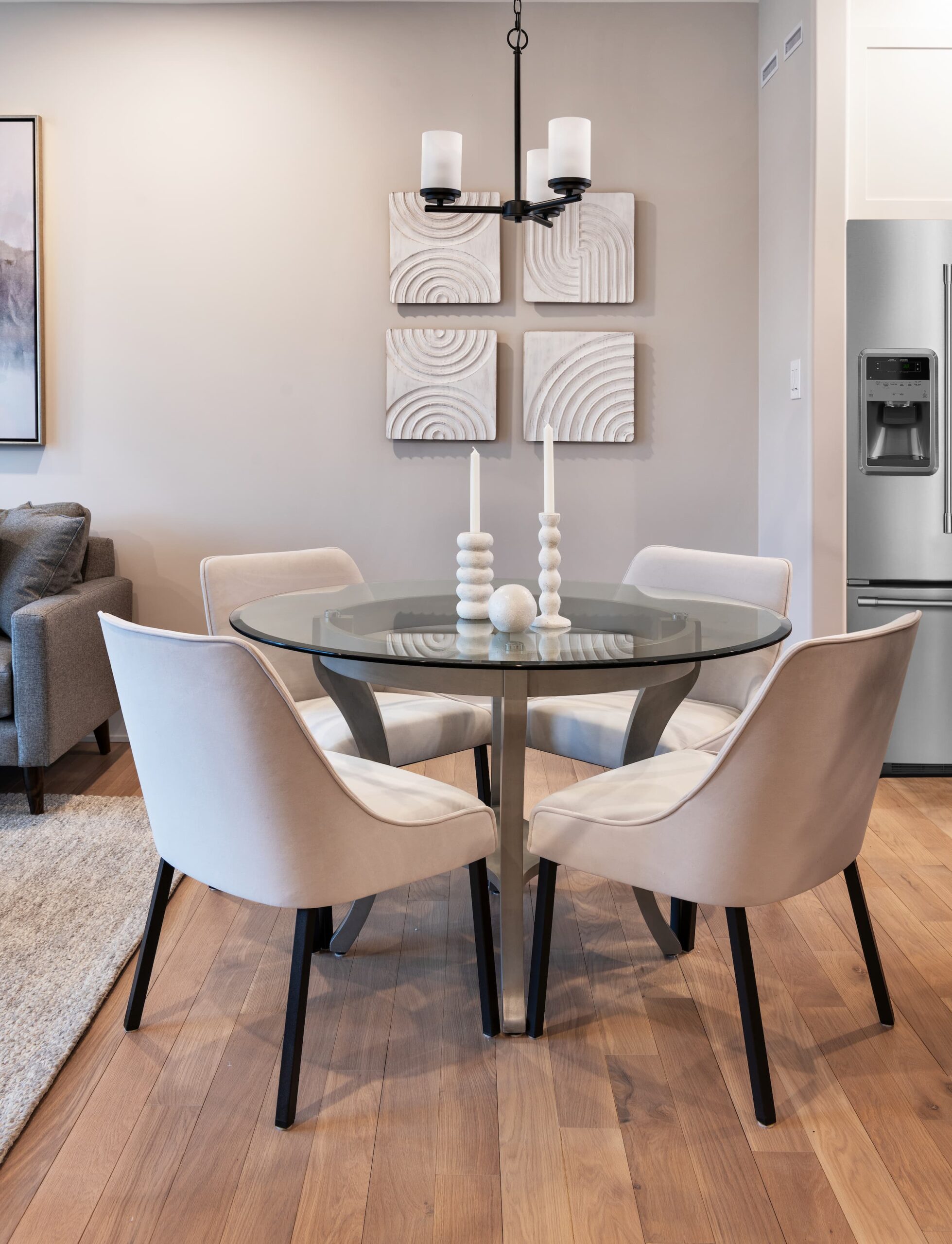 A round glass dining table with white chairs around it
