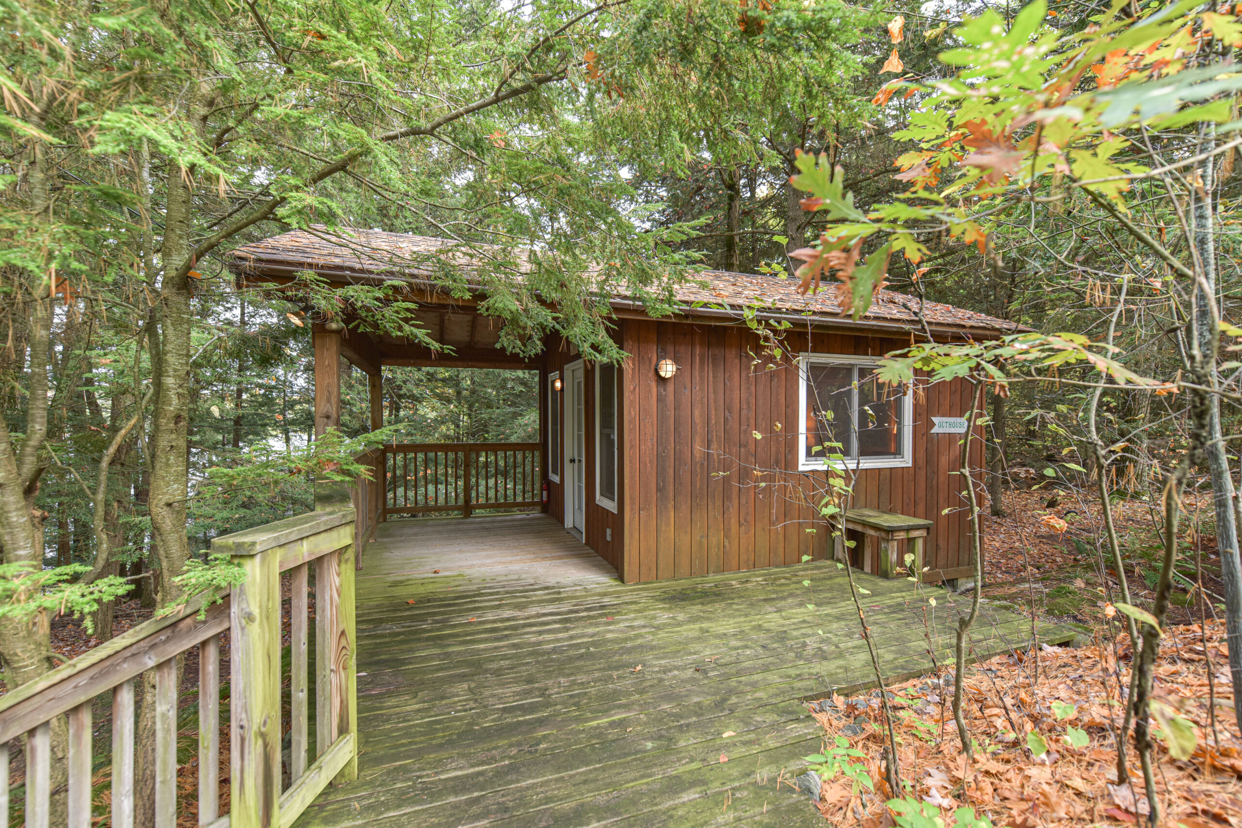 A deck leads to a small wood cabin