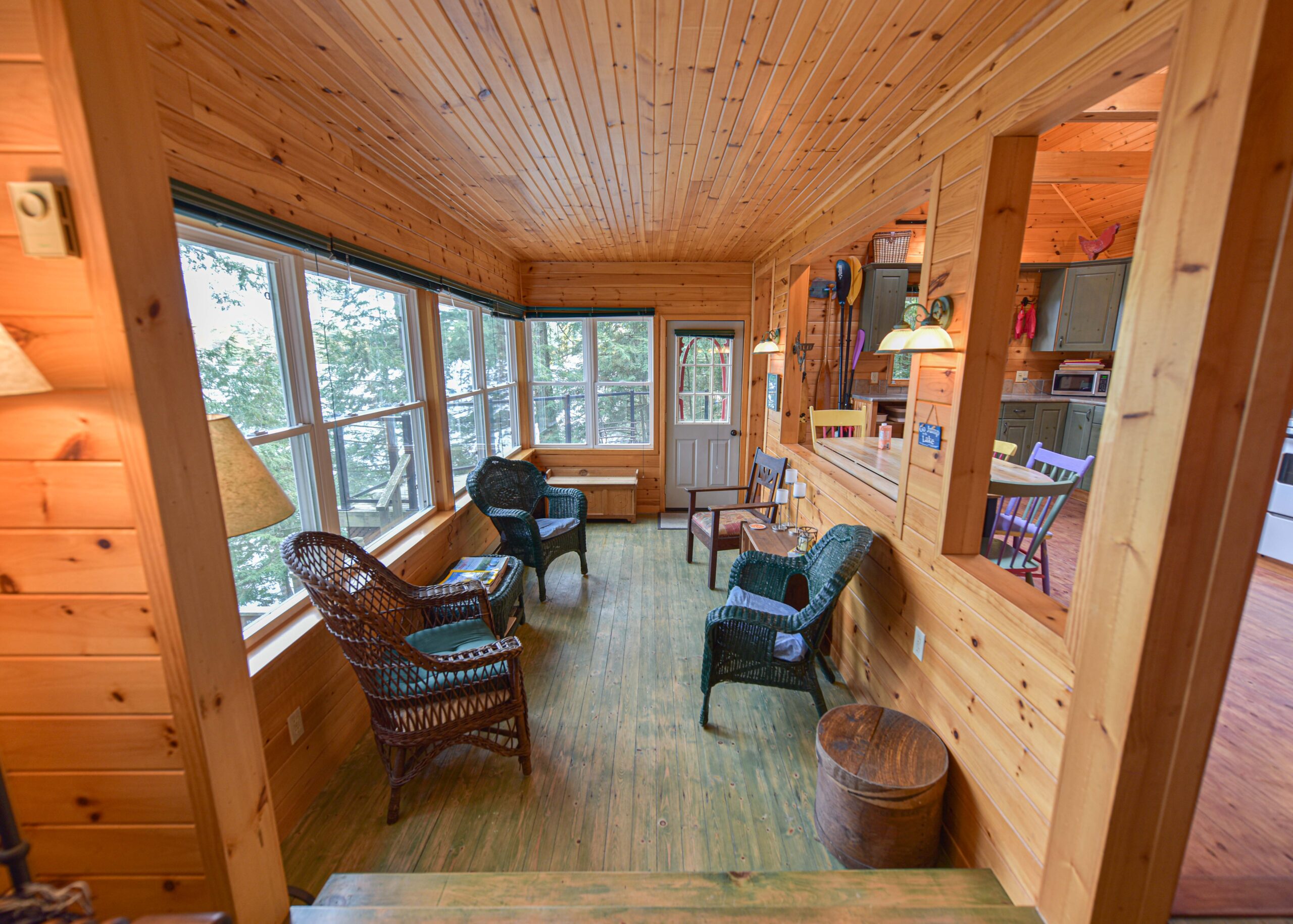 A wood panelled room with large windows and chairs