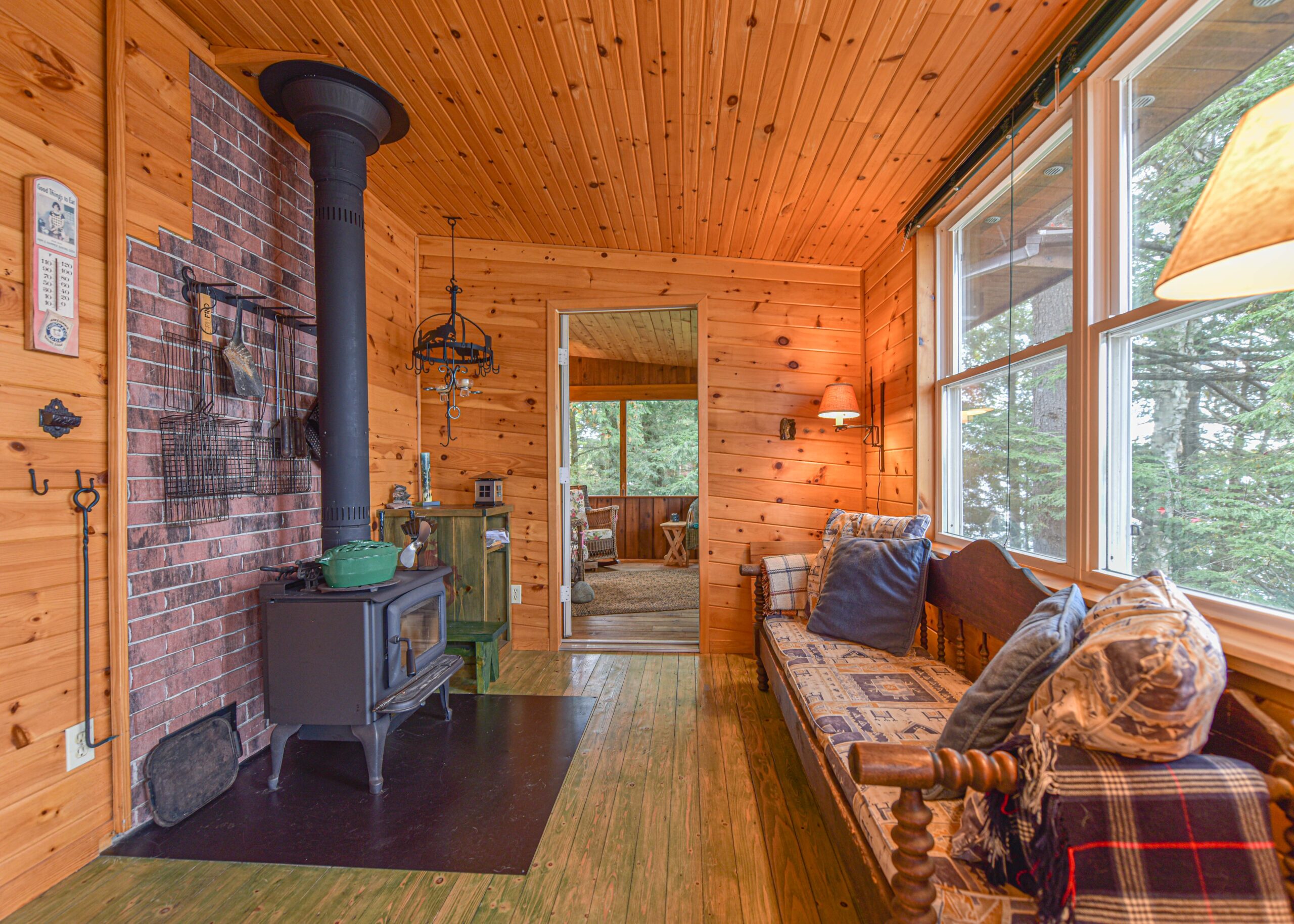 A wood stove faces a wood couch with a patterned cushion