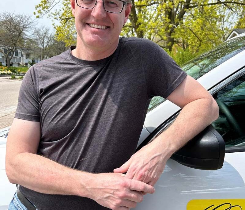A man standing beside his weather vehicle