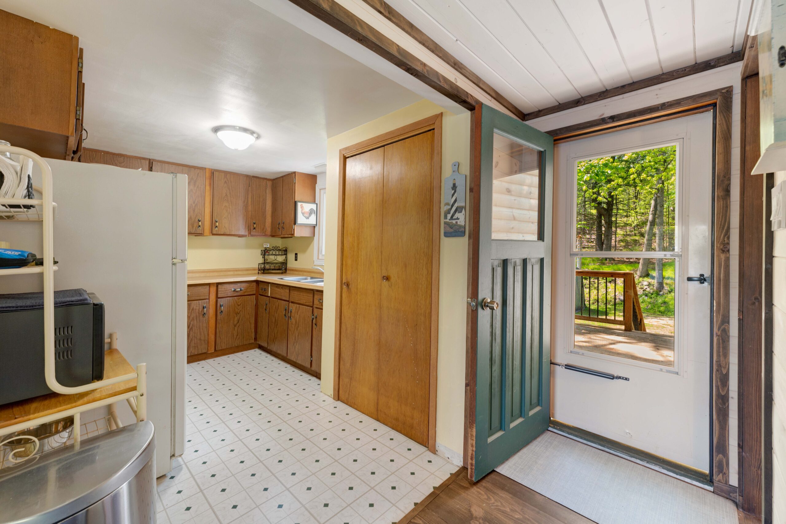The kitchen next to an open teal door that leads outside