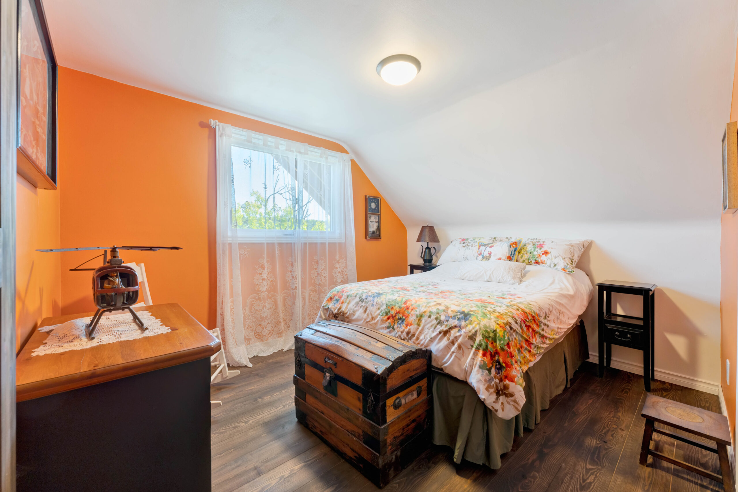 A floral bedspread on a large bed in an orange room