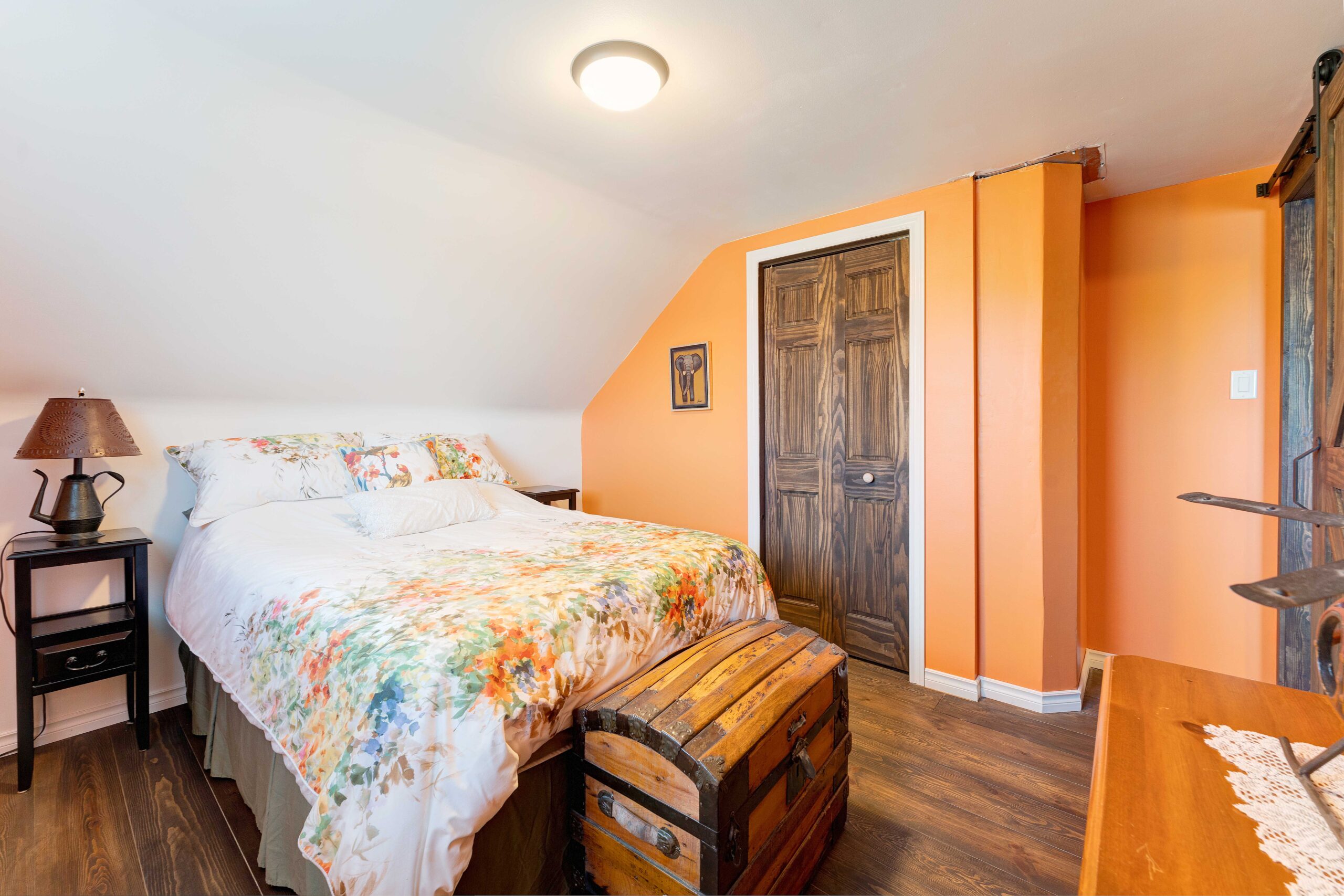 A floral bedspread on a large bed in an orange room