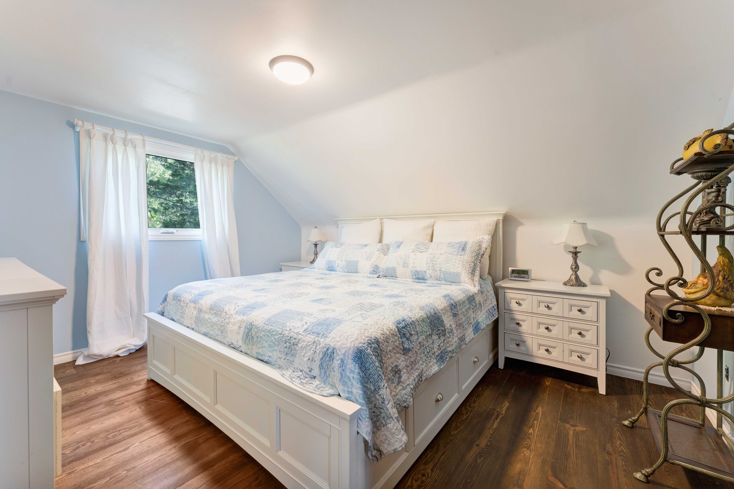 A large white and blue bed in a white bedroom