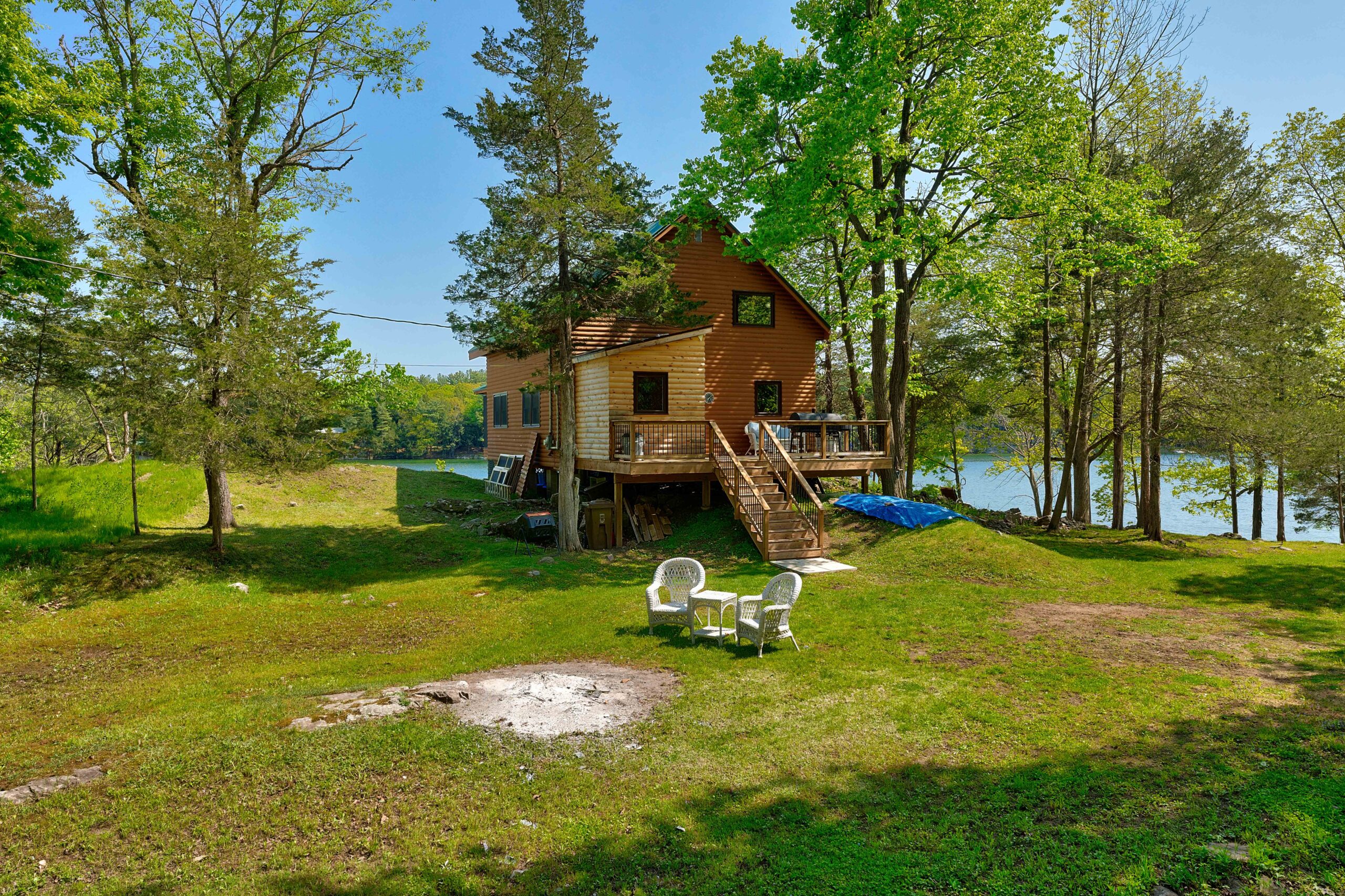 A huge grassy lawn next to the wood cottage