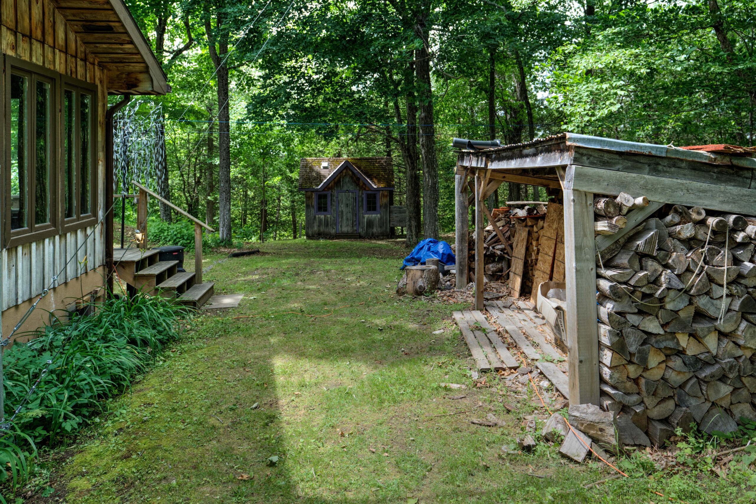 A grass yard with a shed in the distance