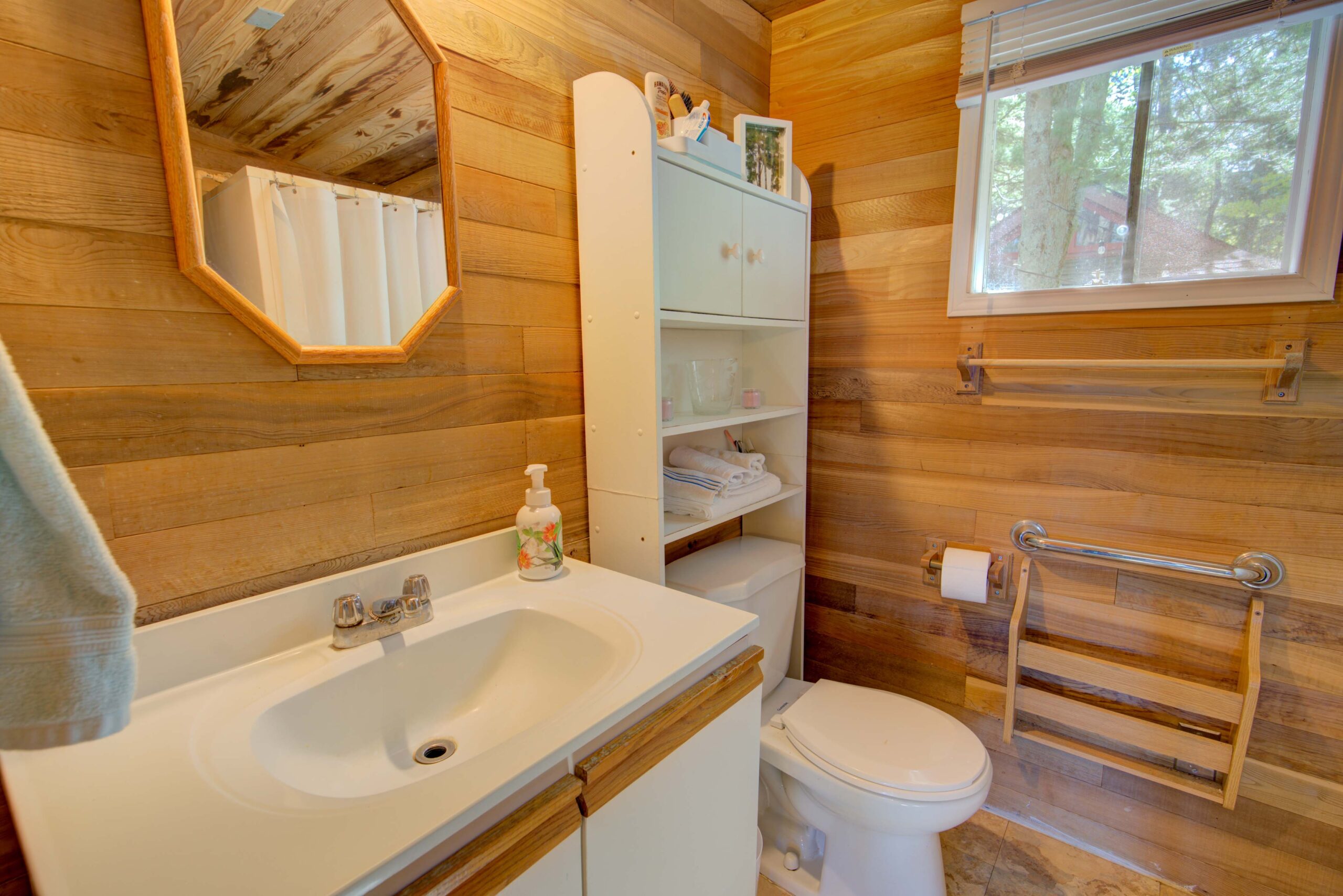 A wood-paneled bathroom with white fixtures