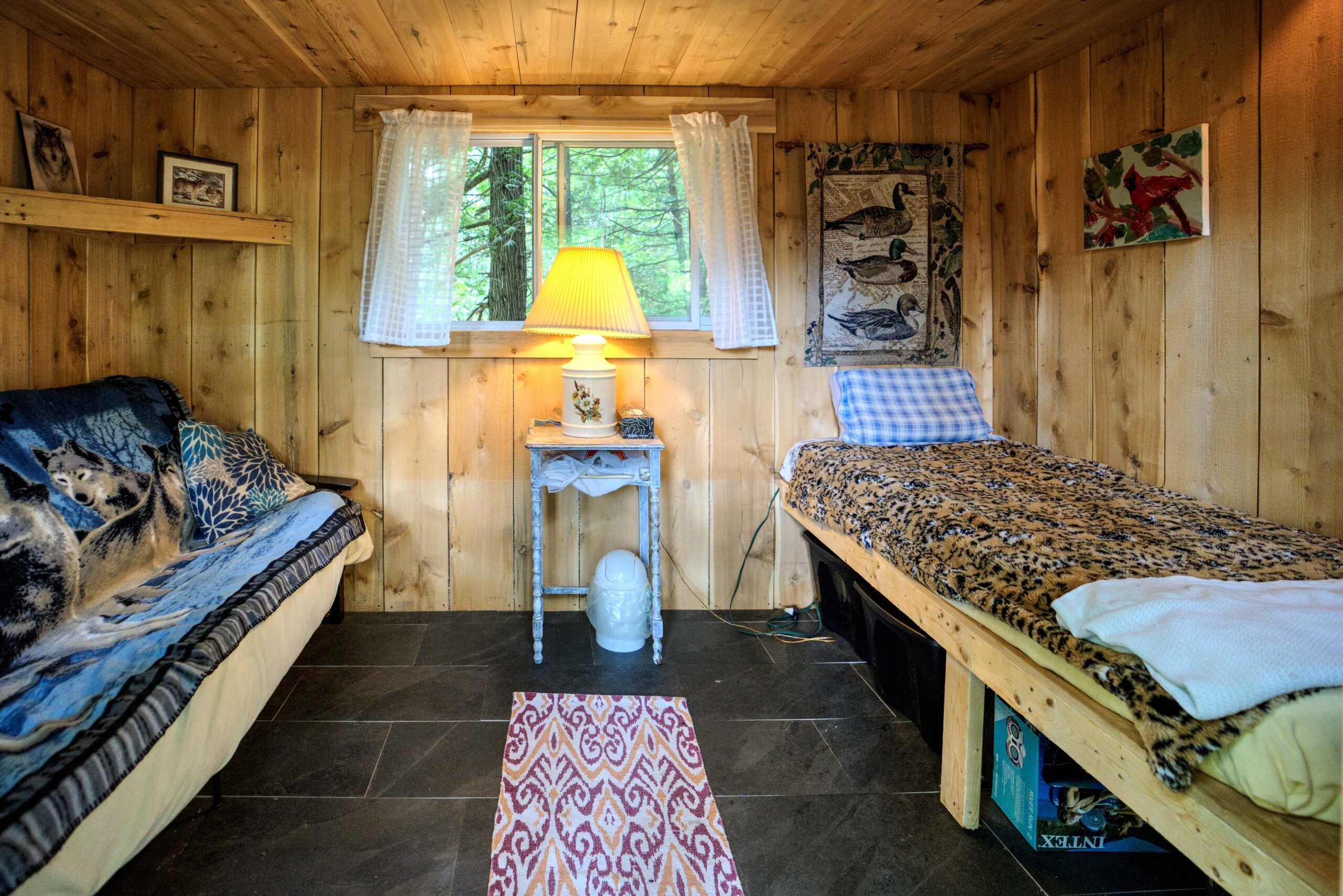 Two twin beds on either side of a wood cabin