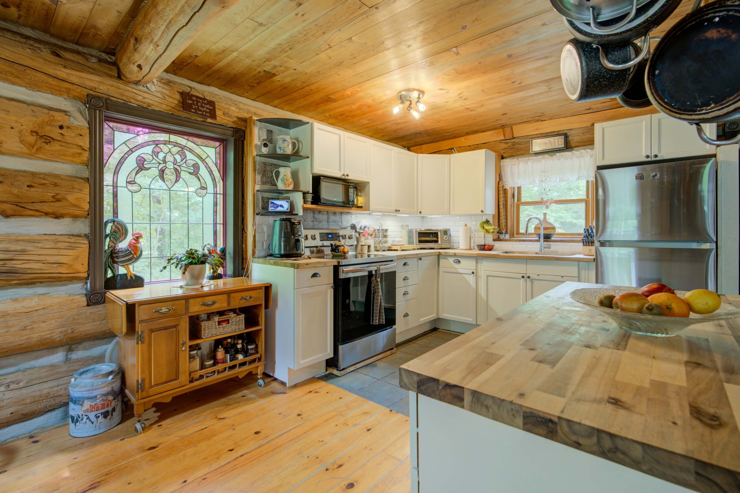 A wood-paneled room with white cabinets and a stainless steel oven