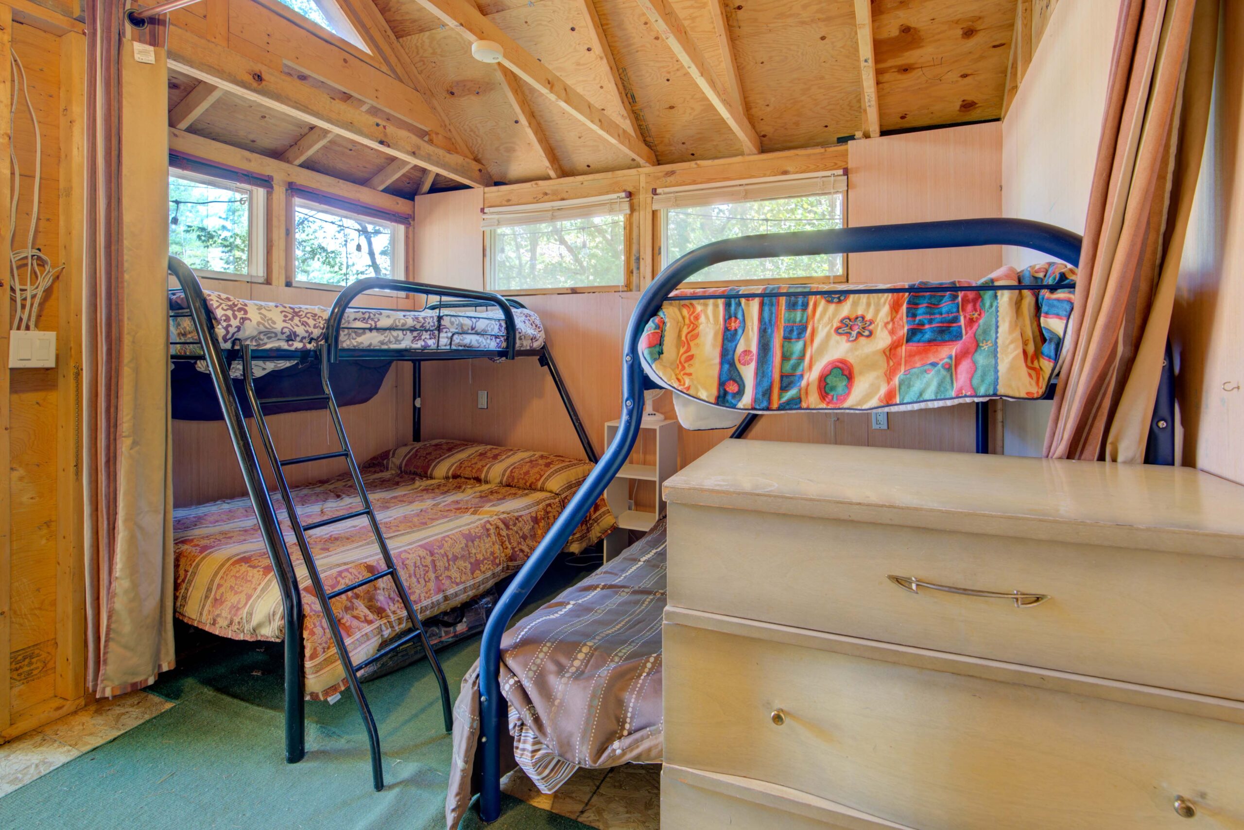 Two wire bunk beds face each other in a wood room