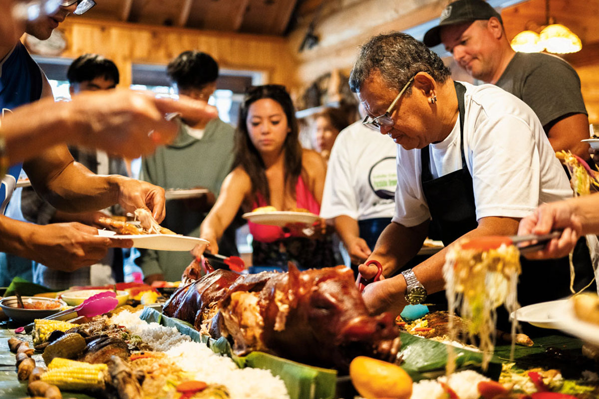 Family serving themselves food from the boodle fight