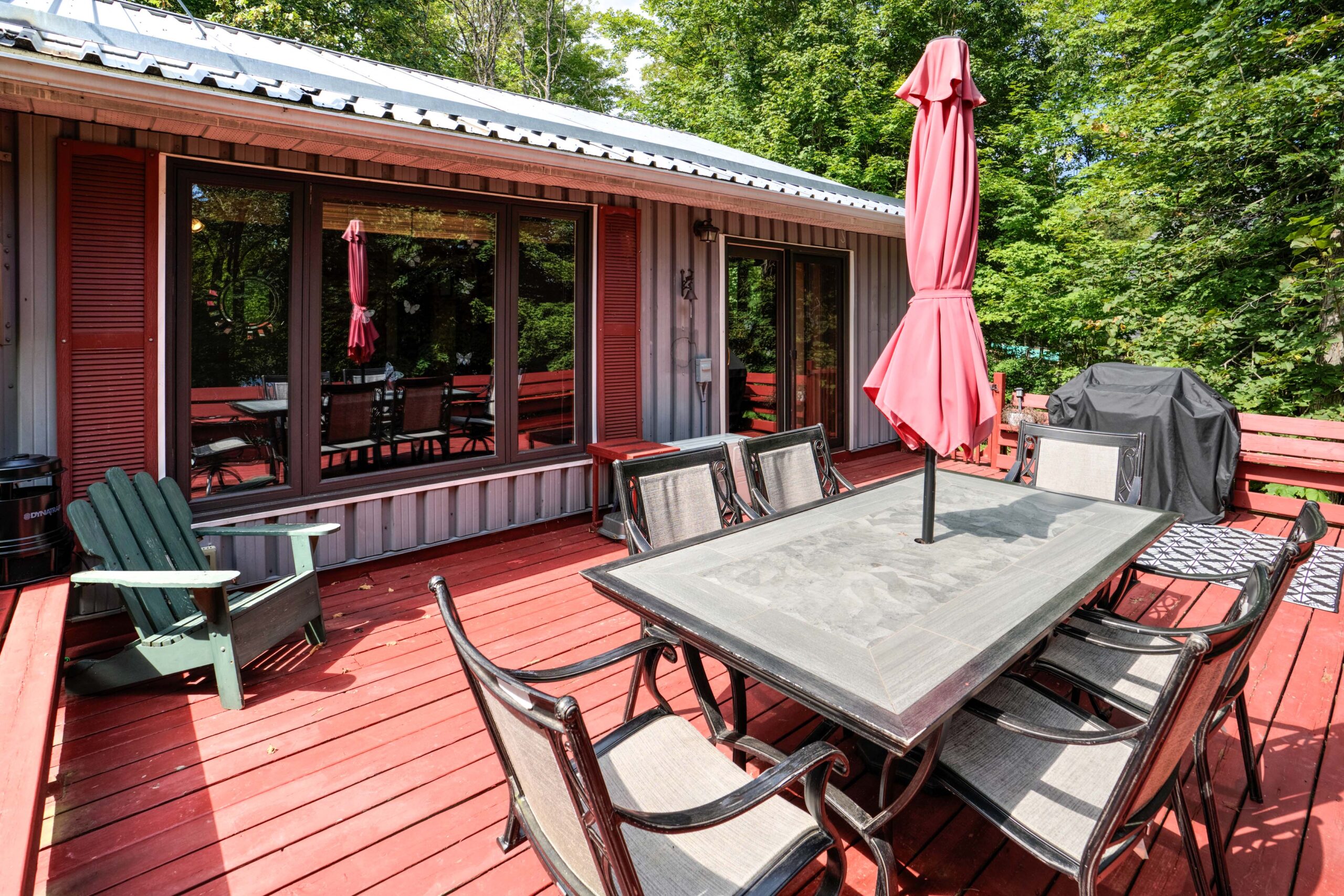A large glass dining table on a red deck