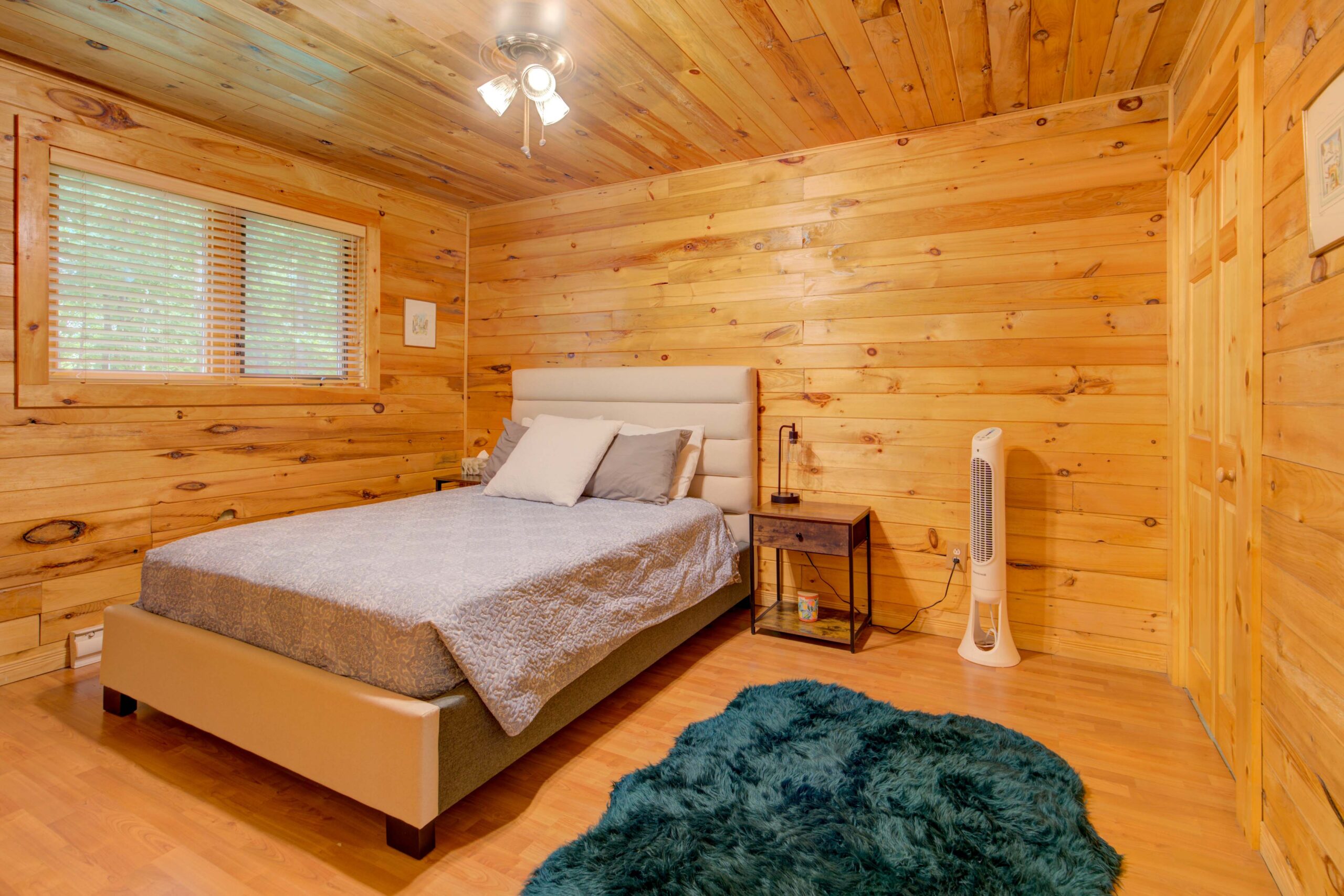 A grey bed in a wood-panelled room