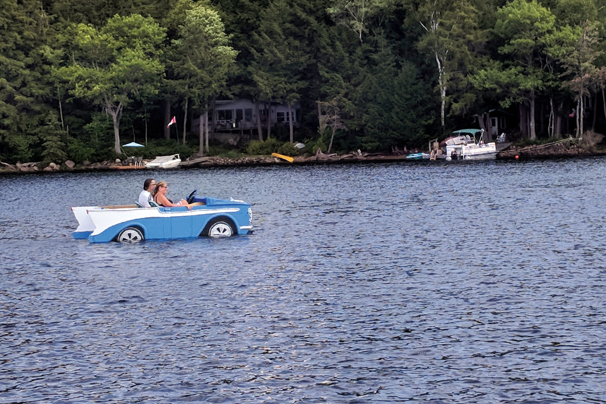 two people drive a boat designed to look like a '57 chevy