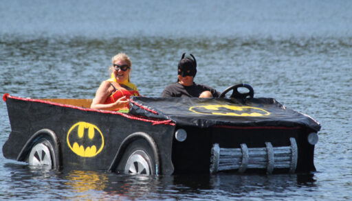 a man and woman in a boat decorated to look like a batmobile