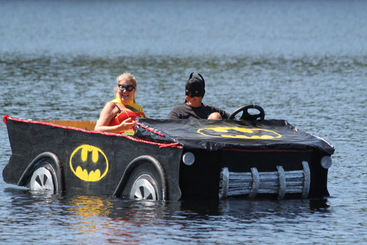 a man and woman in a boat decorated to look like a batmobile