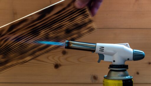 A gas torch burning a piece of wood