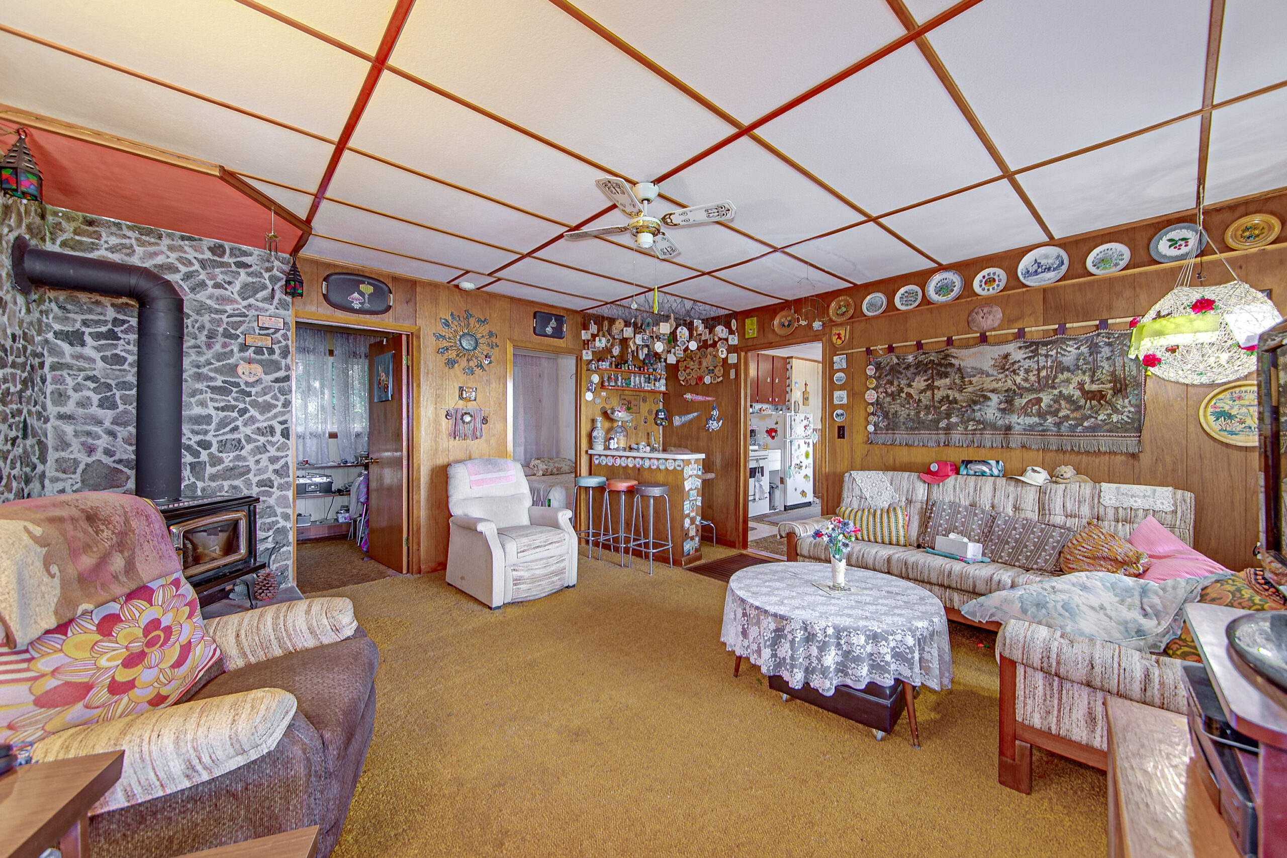 Patterned couches face each other in a living room with wood walls