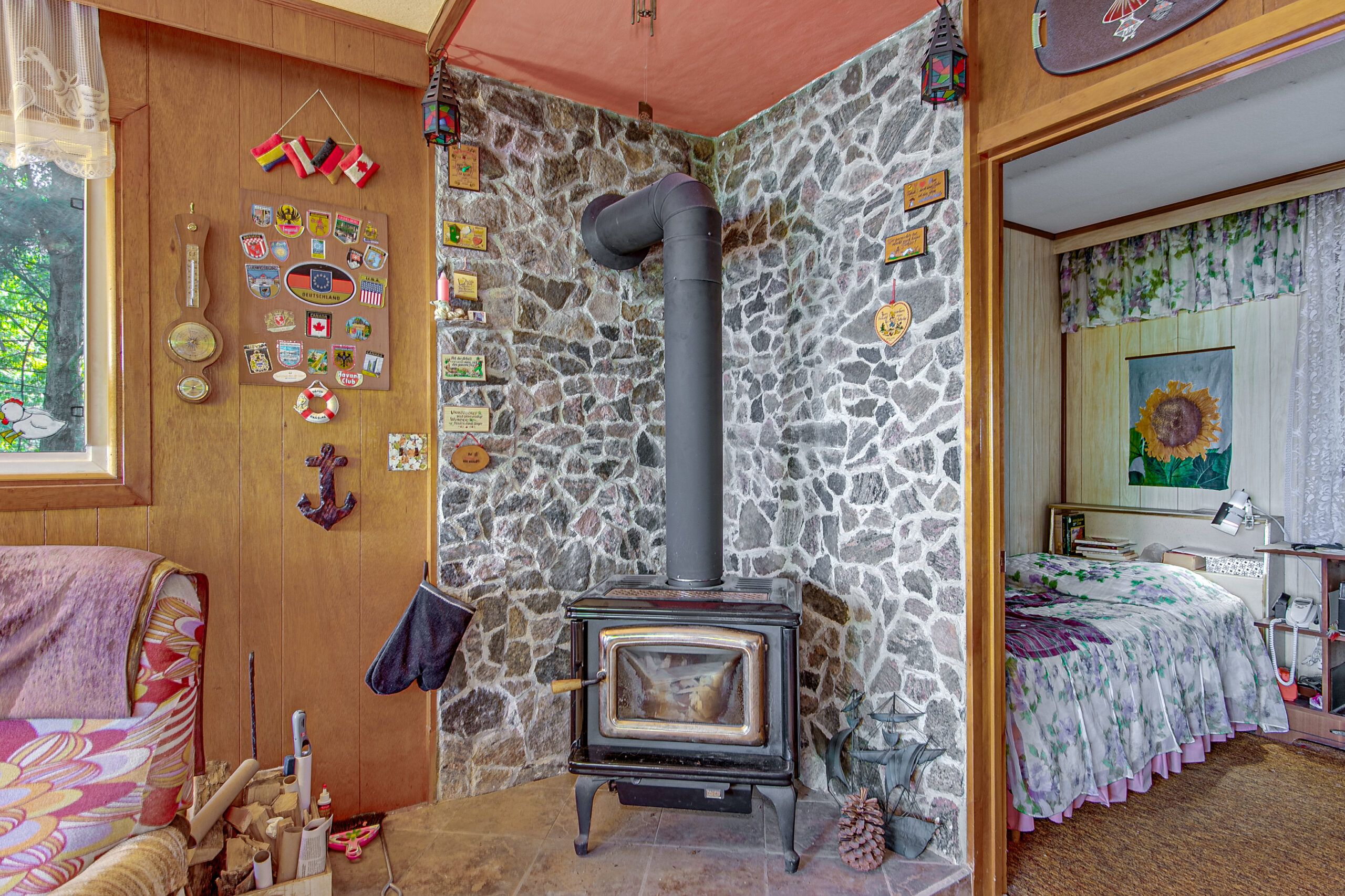 A black wood stove in a corner with stone walls