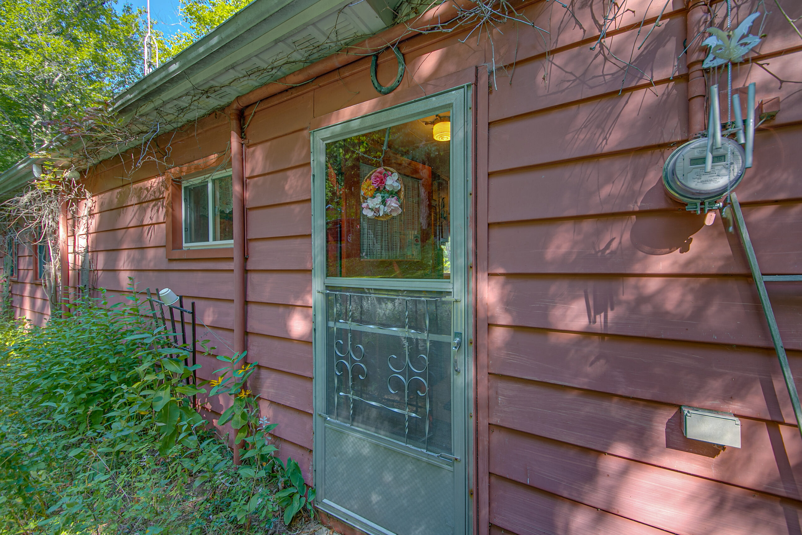 A green screen door on a red cottage