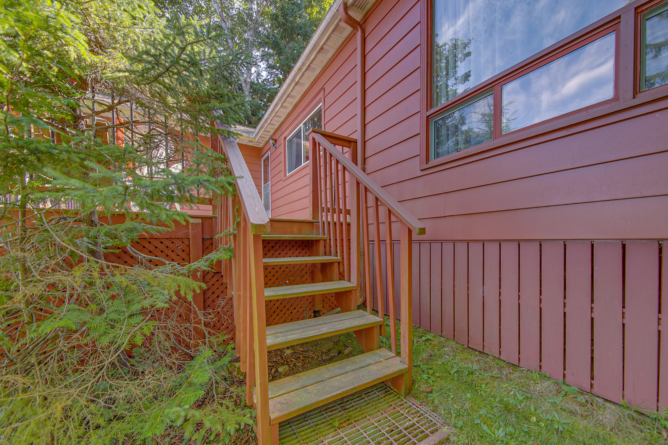 A small stairway leads down from the red cottage