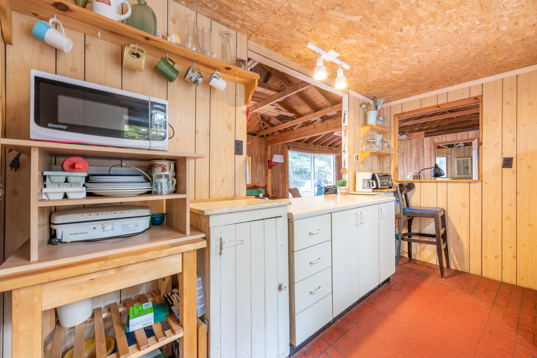 A wood kitchen with white cabinets and red floors