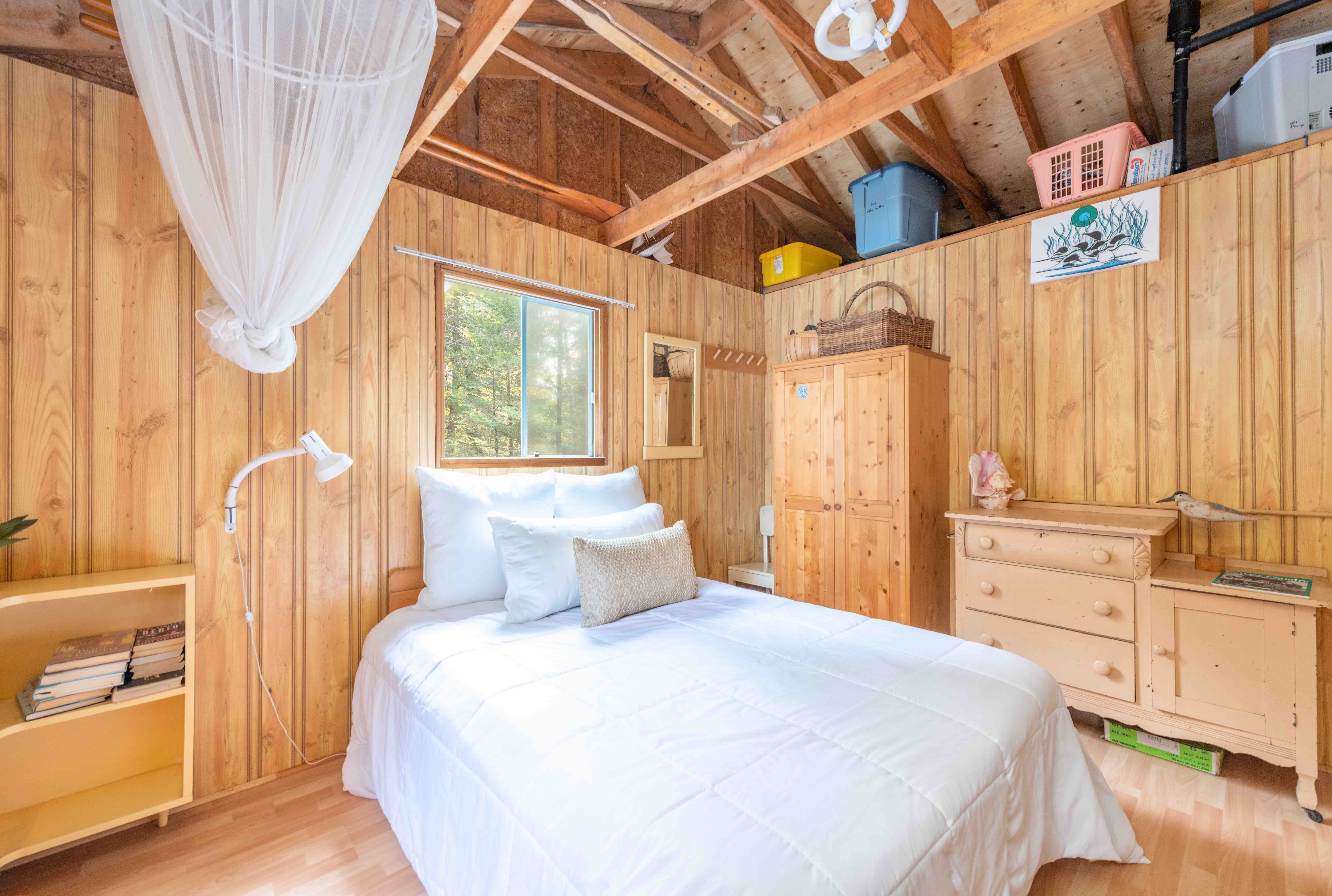 A white bed in a wood room