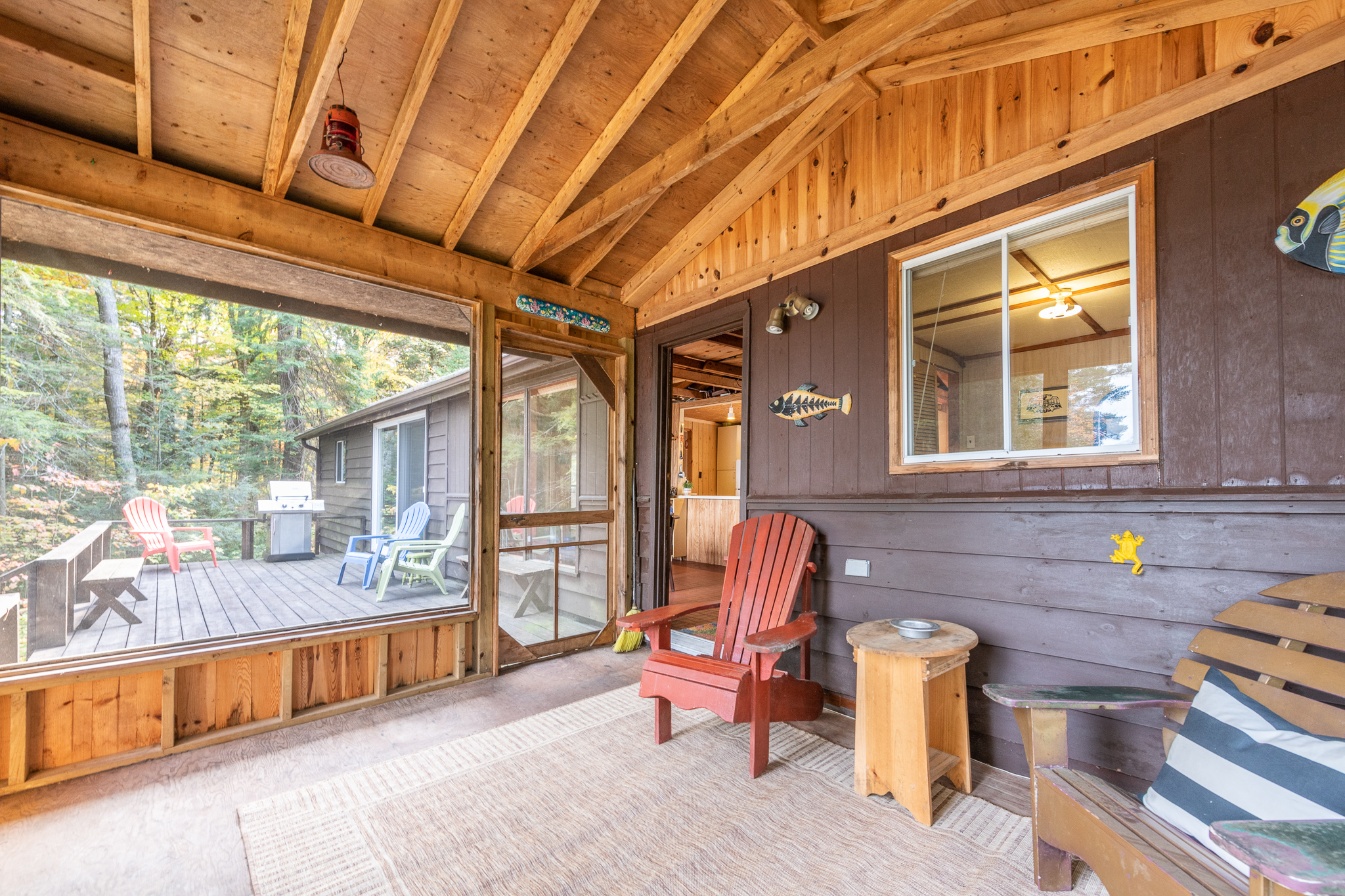 A grey wood screened-in porch with vaulted ceilings