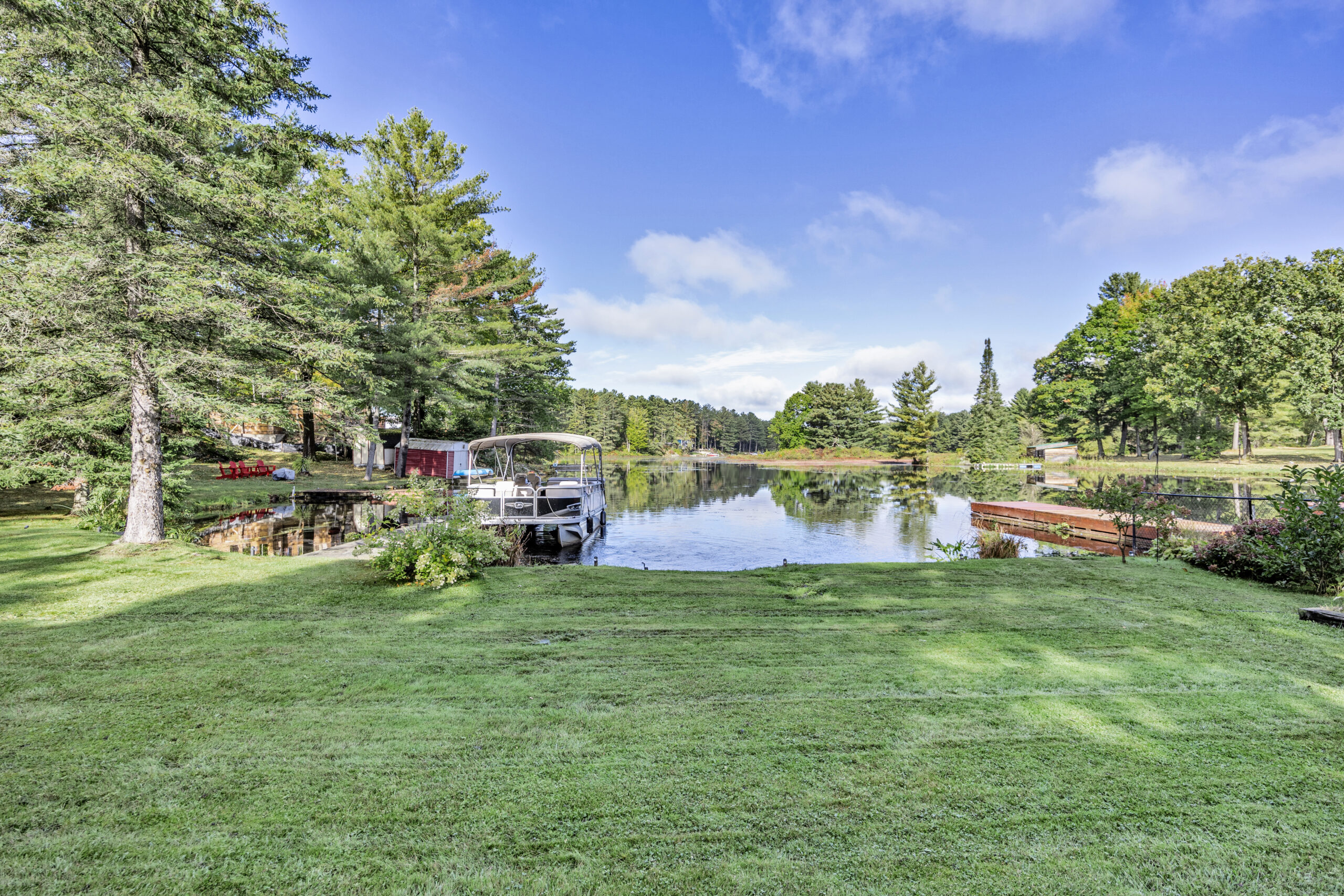 A large grassy yard on the shores of a small lake