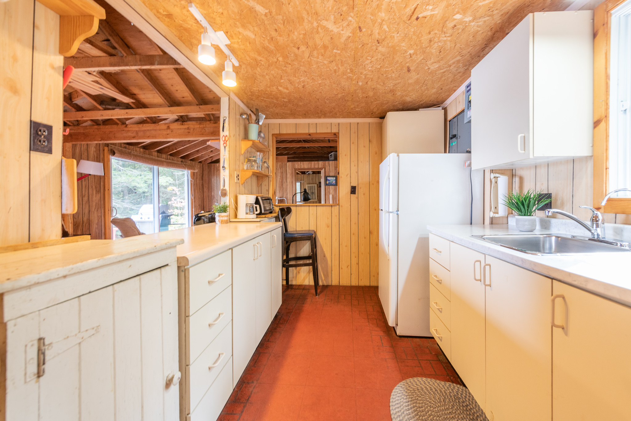 A wood kitchen with white cabinets and red floors