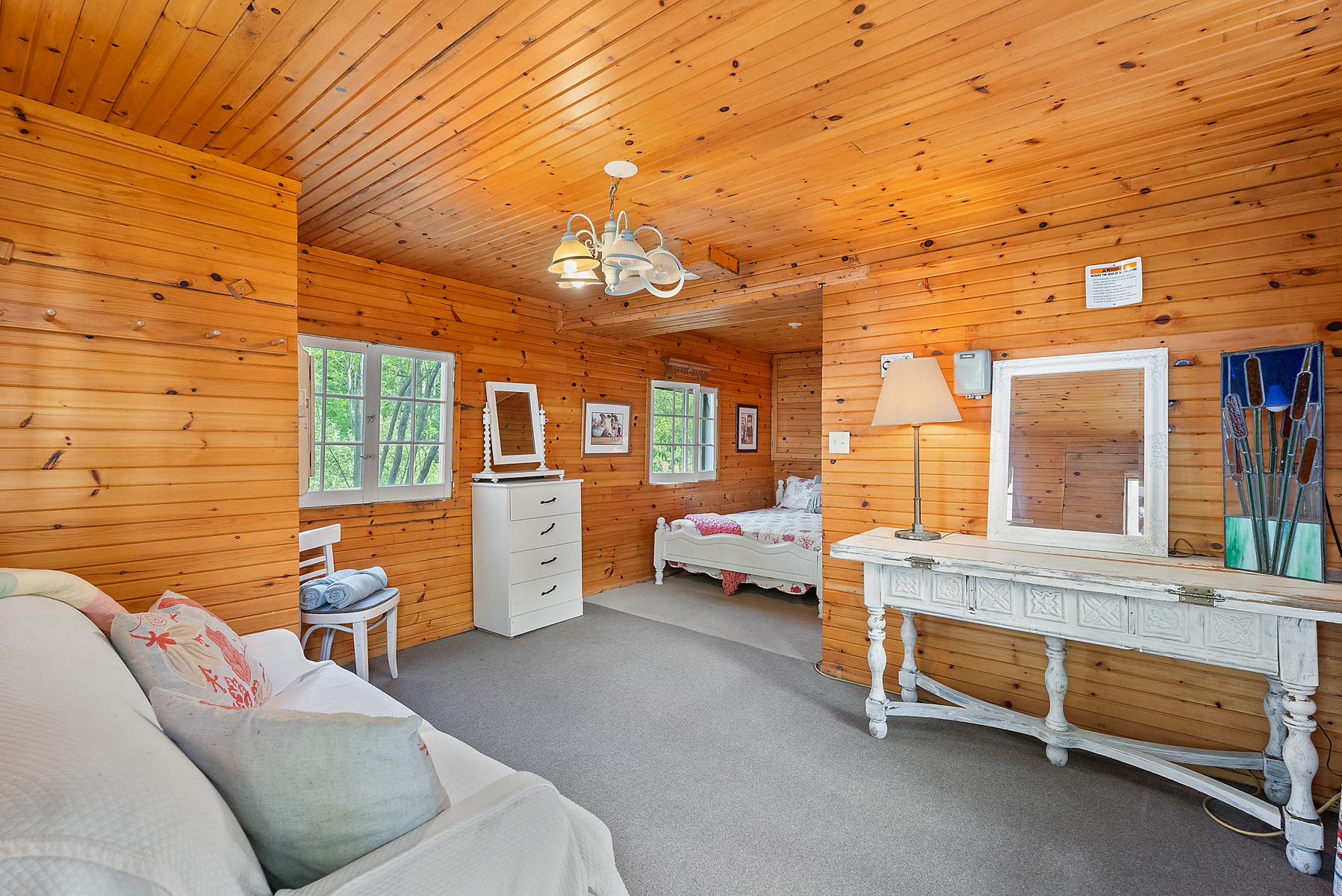 A white couch in a wood-paneled room