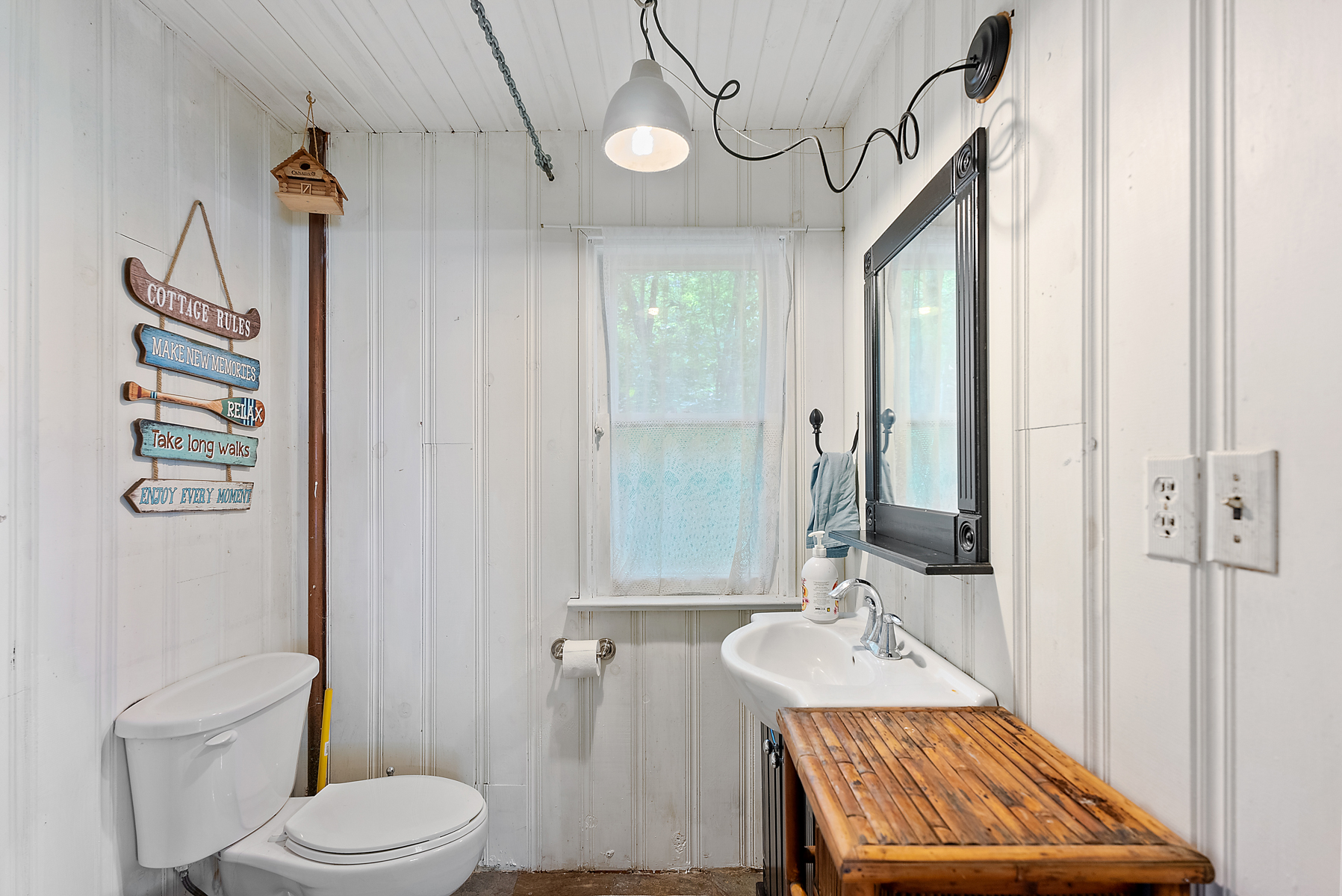 A white bathroom with a toilet facing the vanity