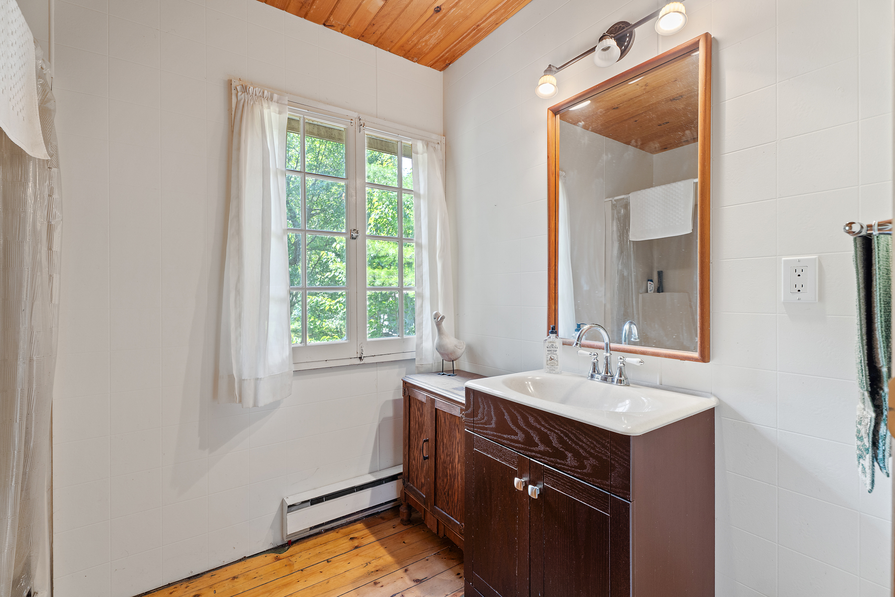 A white kitchen with a brown wood vanity and a mirror