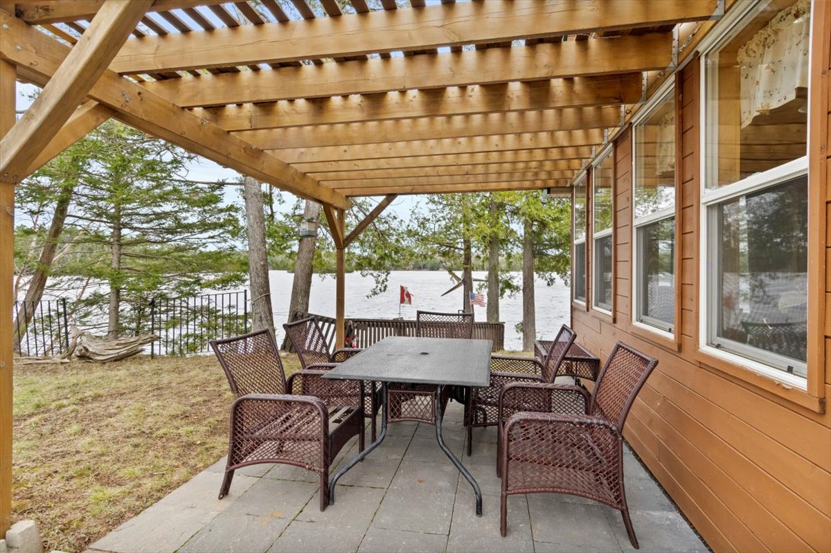 A covered pergola with a patio set