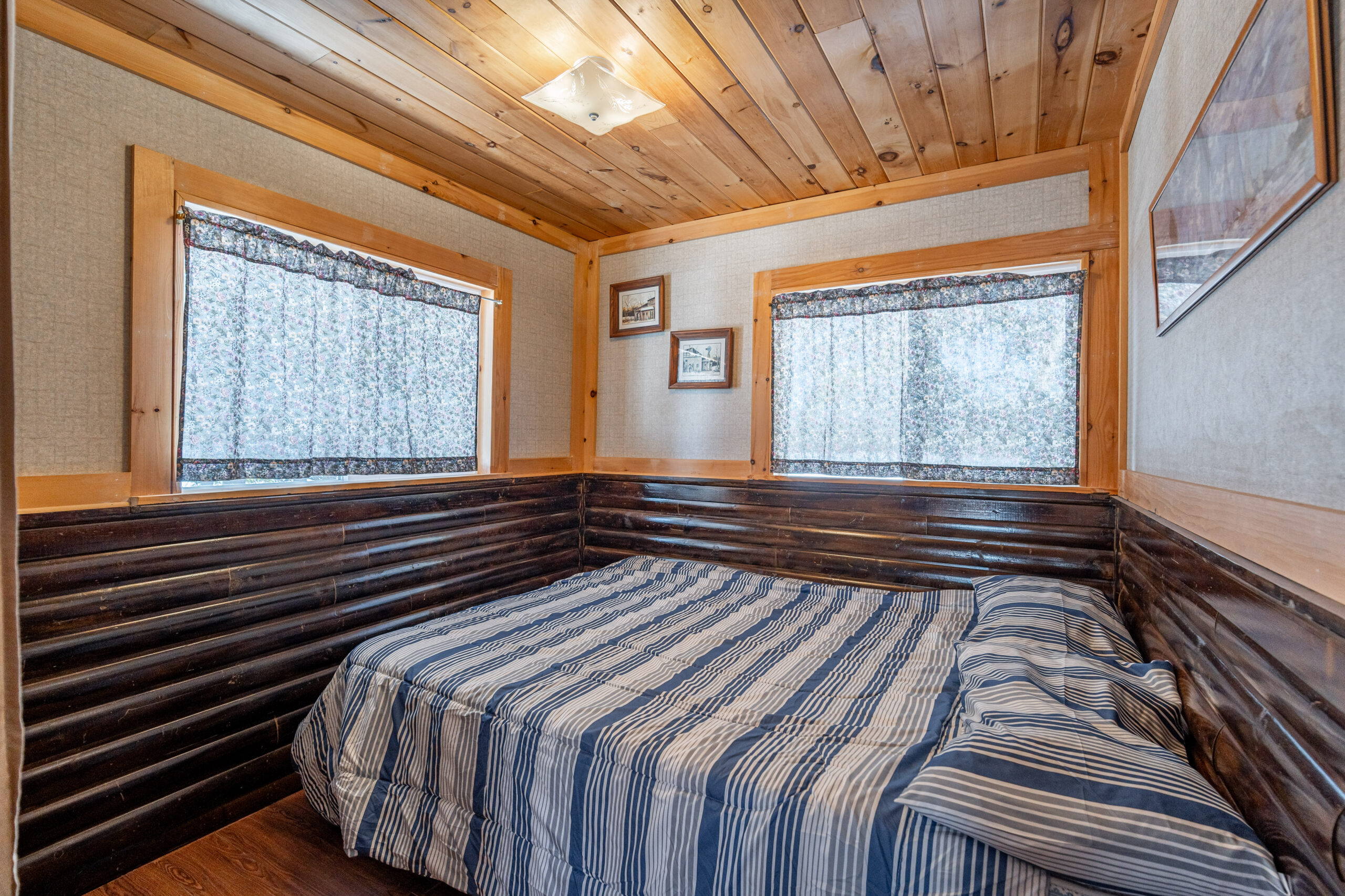 A striped bed in a wood cabin