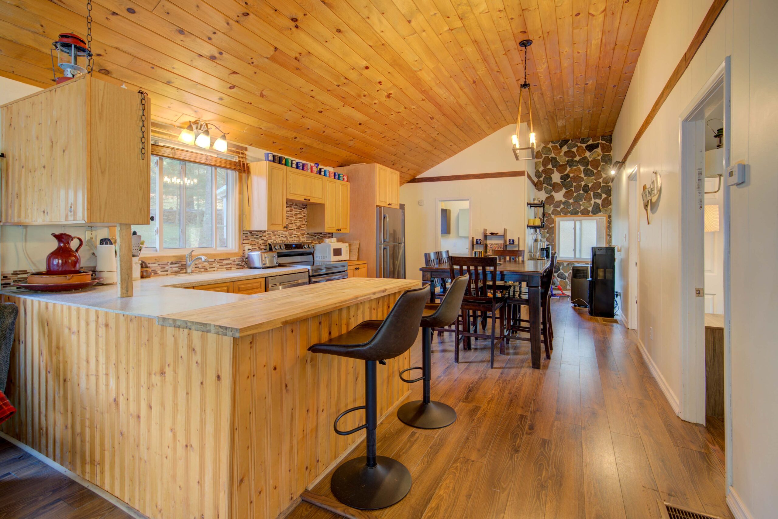 A wood kitchen with black barstools