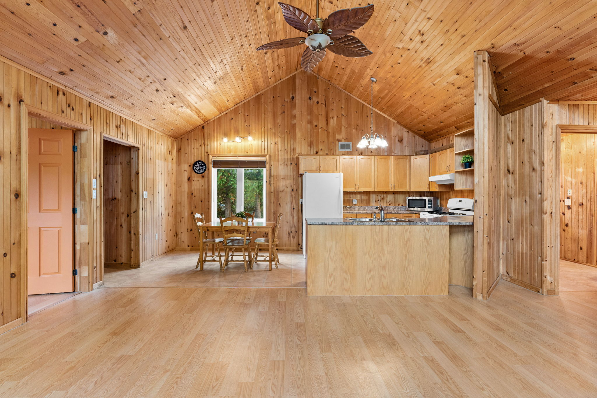 A large wood kitchen and dining area with vaulted ceilings