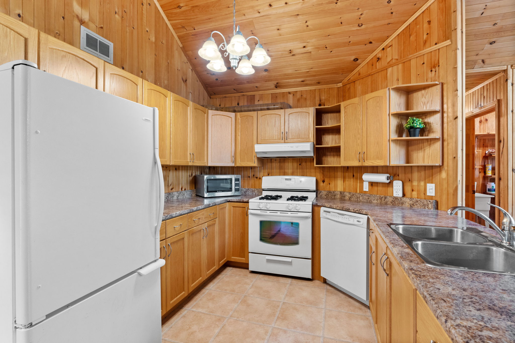 A wood panelled kitchen with white appliances