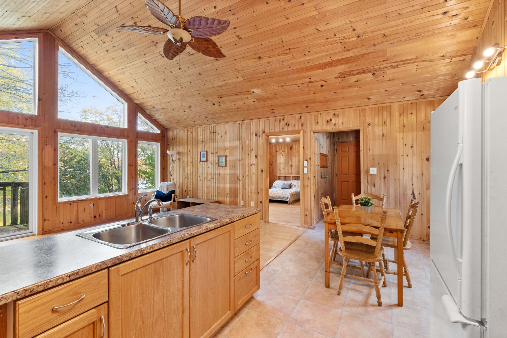 A wood panelled kitchen looks out into the family room
