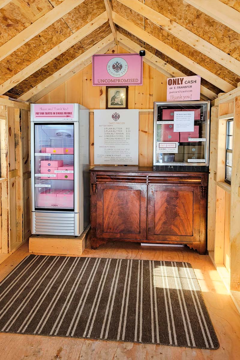 a photo of a shed interior with a fridge and a shelf