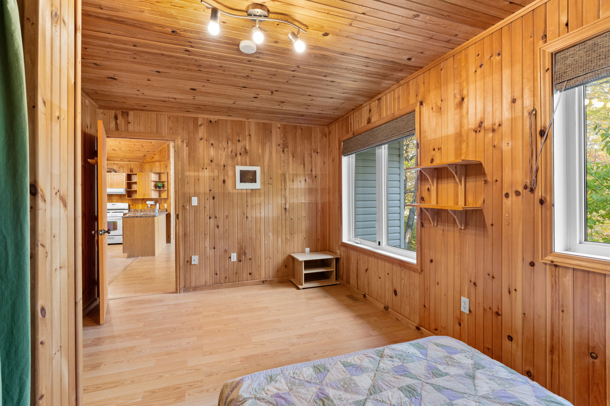 A white bed set into a wood panelled bedroom