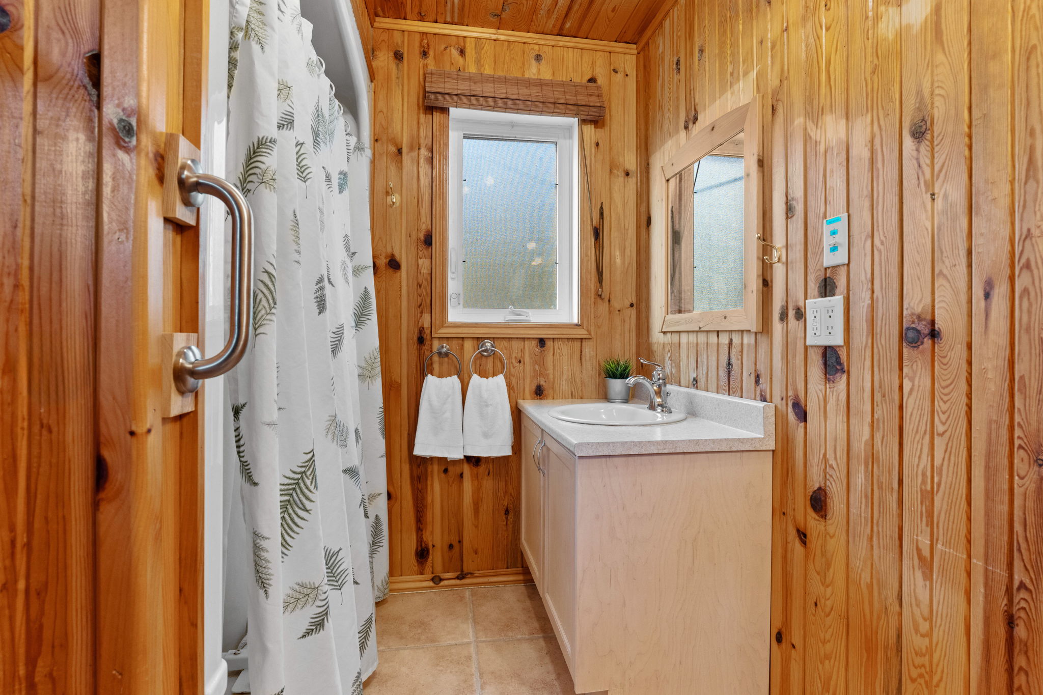 A small bathroom with a white vanity and white shower curtain